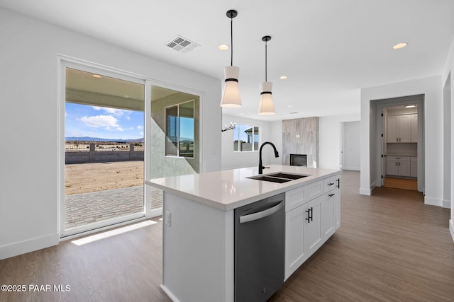 kitchen with stainless steel dishwasher, sink, pendant lighting, a center island with sink, and white cabinetry