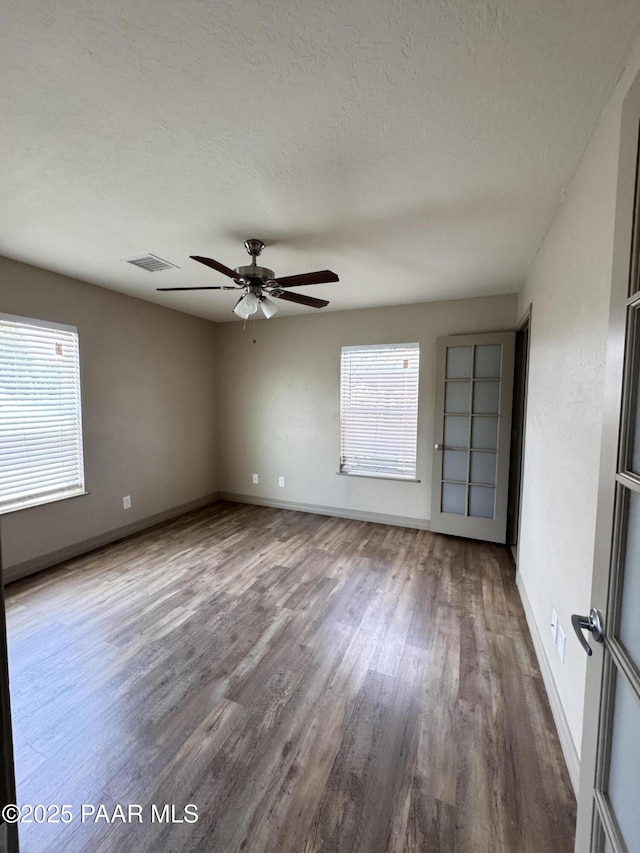 7728 E Vista Cir, Prescott Valley, AZ 86314 - unfurnished room with wood finished floors, baseboards, ceiling fan, and a textured ceiling