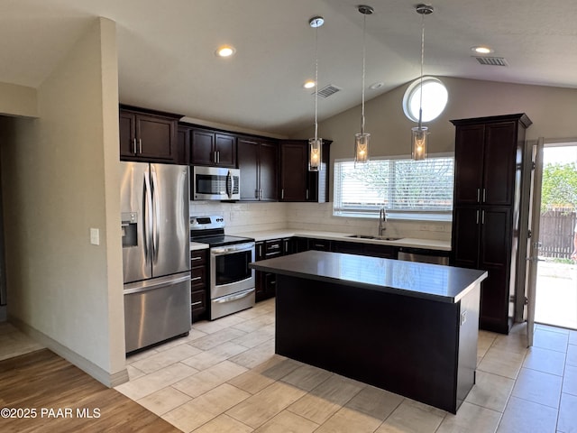 7728 E Vista Cir, Prescott Valley, AZ 86314 - kitchen with stainless steel appliances, a sink, lofted ceiling, a kitchen island, and backsplash