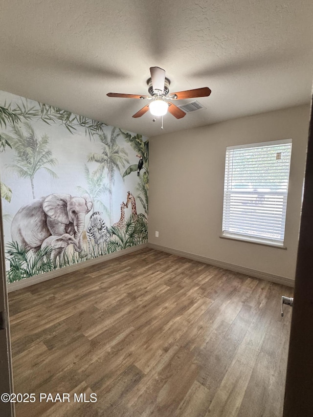 7728 E Vista Cir, Prescott Valley, AZ 86314 - unfurnished room featuring wood finished floors, ceiling fan, baseboards, a textured ceiling, and wallpapered walls