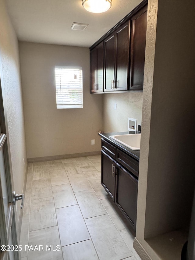 7728 E Vista Cir, Prescott Valley, AZ 86314 - kitchen featuring dark brown cabinets, a sink, and baseboards
