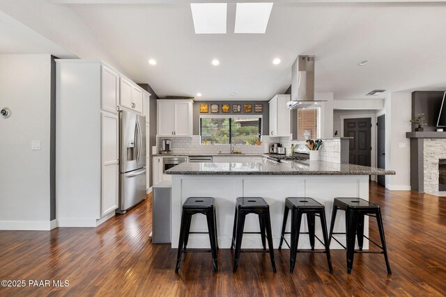 1210 Tanglewood Rd, Prescott, AZ 86303 - kitchen featuring stainless steel appliances, island range hood, a kitchen breakfast bar, decorative backsplash, and recessed lighting