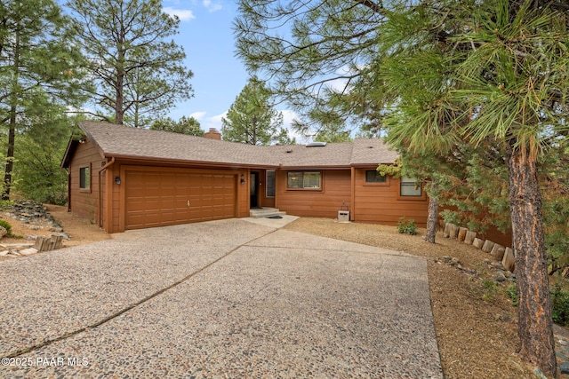 1210 Tanglewood Rd, Prescott, AZ 86303 - view of front of property with an attached garage, a chimney, driveway, and roof with shingles
