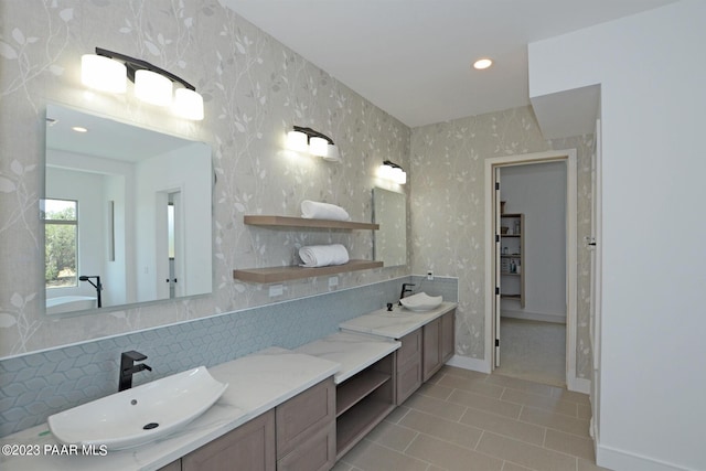 bathroom featuring tile patterned floors, backsplash, vanity, and wallpapered walls