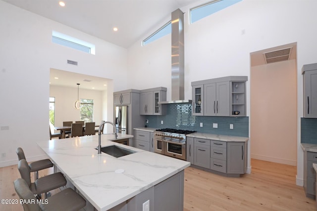 kitchen featuring visible vents, appliances with stainless steel finishes, gray cabinets, and a sink