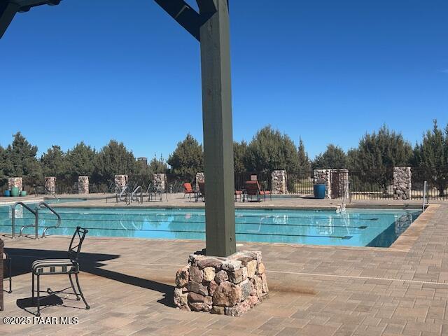 community pool featuring a patio area and fence