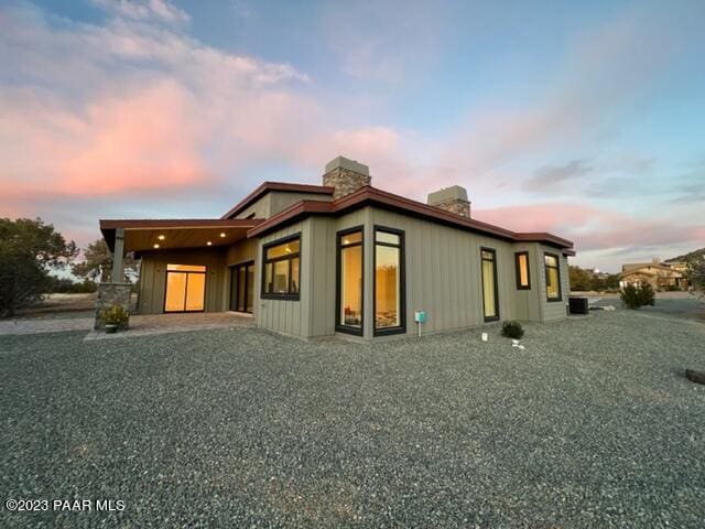 property exterior at dusk featuring a patio area