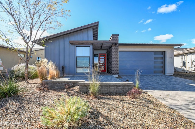 5393 Crescent Edge Dr, Prescott, AZ 86301 - view of front of house featuring board and batten siding, decorative driveway, and an attached garage