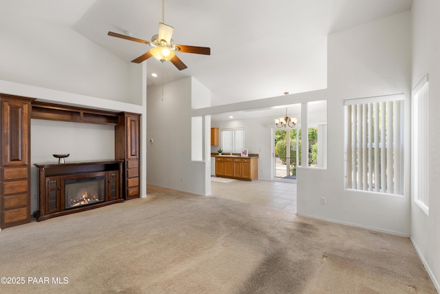 1634 Addington Dr, Prescott, AZ 86301 - unfurnished living room featuring high vaulted ceiling, a glass covered fireplace, a chandelier, light colored carpet, and ceiling fan