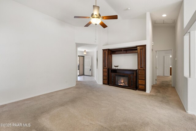 1634 Addington Dr, Prescott, AZ 86301 - unfurnished living room with a high ceiling, light carpet, a ceiling fan, a glass covered fireplace, and attic access