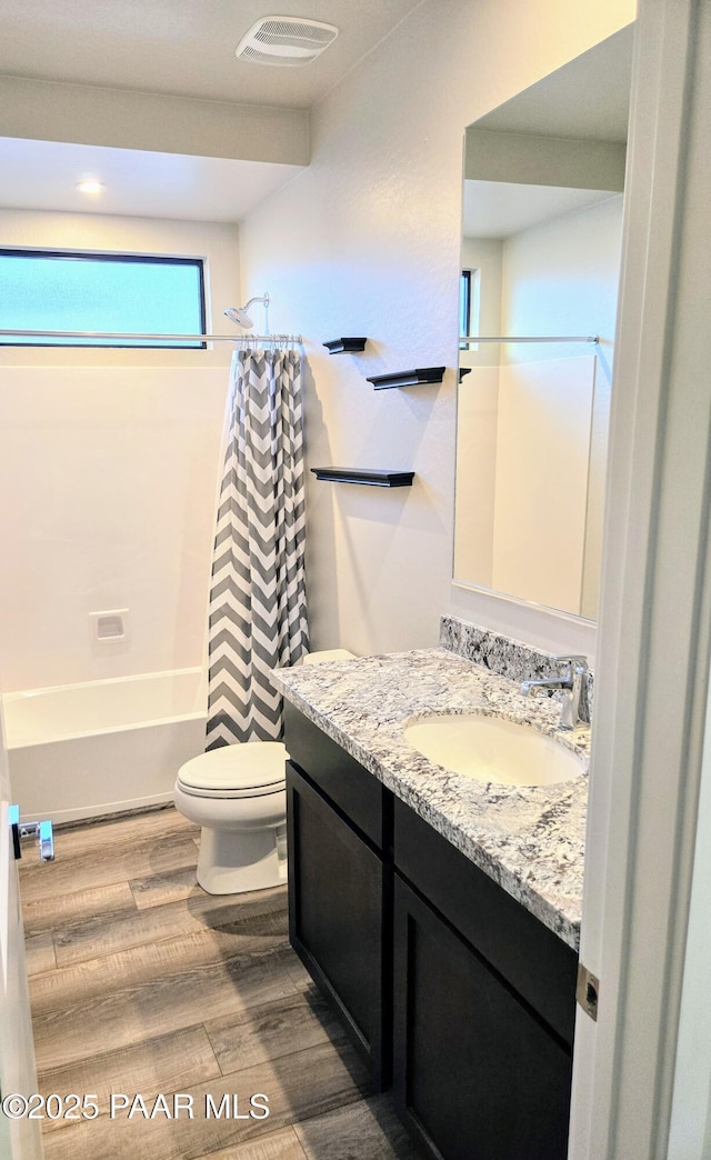 full bathroom with shower / bath combination with curtain, vanity, wood-type flooring, and toilet