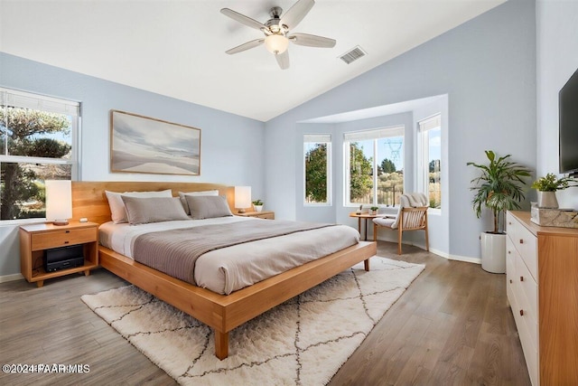 bedroom with dark wood-type flooring, multiple windows, lofted ceiling, and ceiling fan