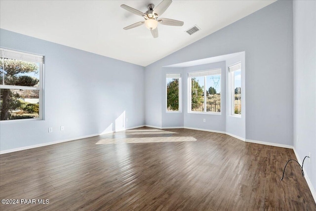 spare room with ceiling fan, dark wood-type flooring, a healthy amount of sunlight, and lofted ceiling