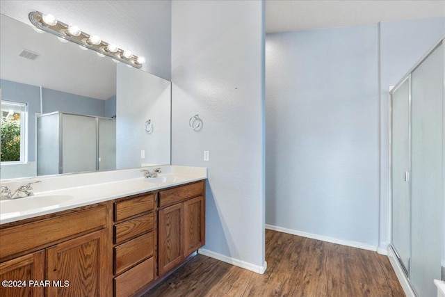 bathroom with vanity, hardwood / wood-style flooring, and walk in shower