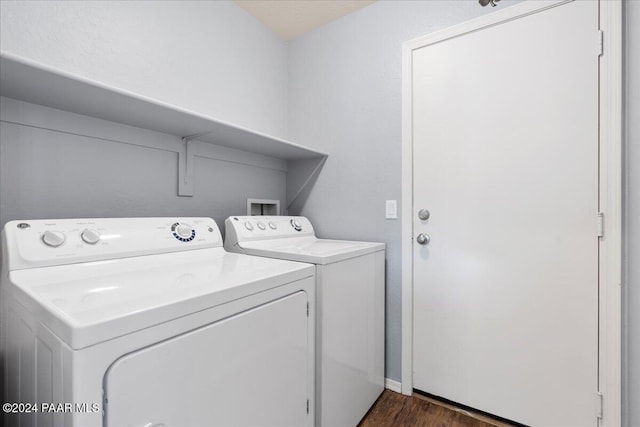 washroom featuring washing machine and dryer and dark wood-type flooring