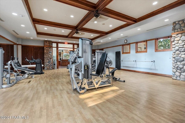 workout area with light hardwood / wood-style floors and coffered ceiling