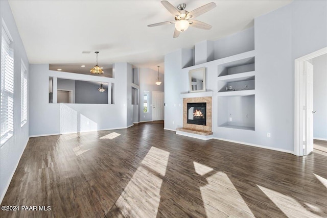 unfurnished living room with ceiling fan, built in features, high vaulted ceiling, and dark wood-type flooring