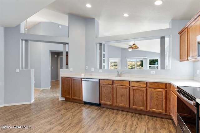 kitchen featuring a notable chandelier, light wood-type flooring, lofted ceiling, and appliances with stainless steel finishes