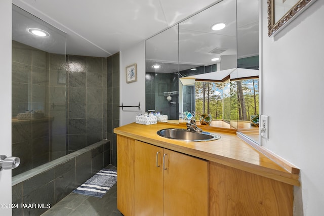 bathroom featuring vanity and tiled shower