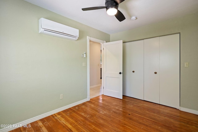 213 N Virginia St, Prescott, AZ 86301 - unfurnished bedroom featuring a wall unit AC, hardwood / wood-style flooring, baseboards, a closet, and a ceiling fan