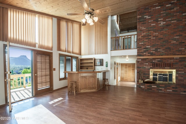 1104 Country Club Dr, Prescott, AZ 86303 - living room featuring a high ceiling, wood finished floors, a mountain view, a brick fireplace, and wooden ceiling