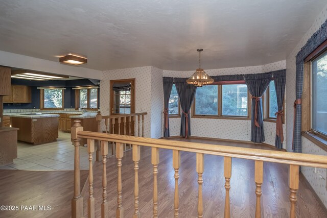 1104 Country Club Dr, Prescott, AZ 86303 - stairway featuring wallpapered walls, healthy amount of natural light, and a chandelier