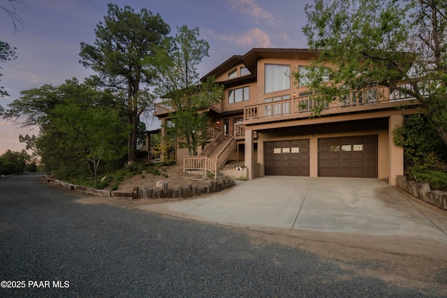 1104 Country Club Dr, Prescott, AZ 86303 - view of front of property featuring stairs, an attached garage, driveway, and stucco siding