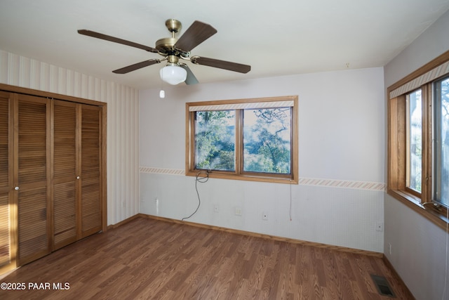 1104 Country Club Dr, Prescott, AZ 86303 - unfurnished bedroom with wood finished floors, a closet, baseboards, a ceiling fan, and wallpapered walls