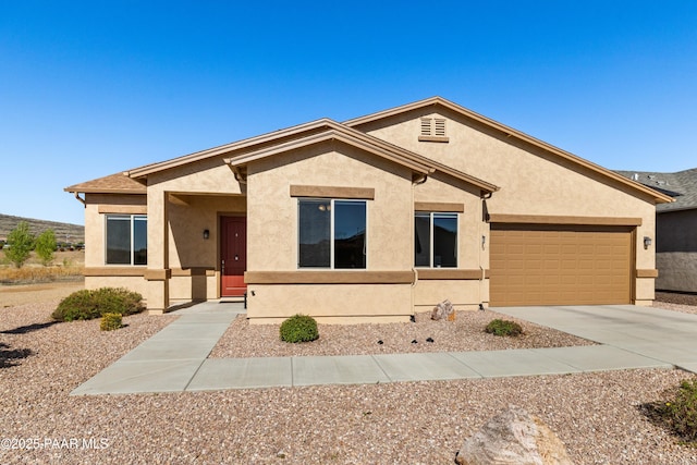 single story home with stucco siding, concrete driveway, and a garage
