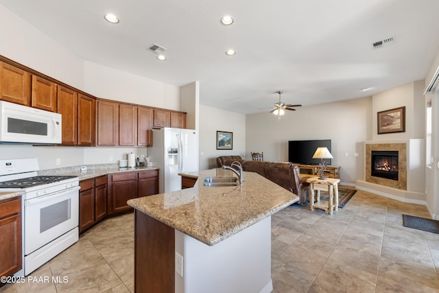 kitchen with ceiling fan, visible vents, a sink, and white appliances