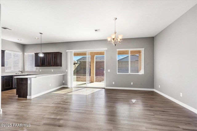 unfurnished living room with hardwood / wood-style floors and an inviting chandelier