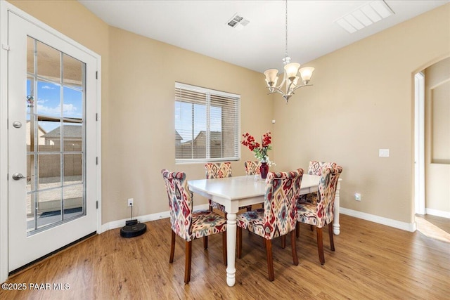 dining area featuring a notable chandelier and light wood-type flooring