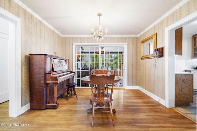 dining room featuring light wood-type flooring, crown molding, and a chandelier