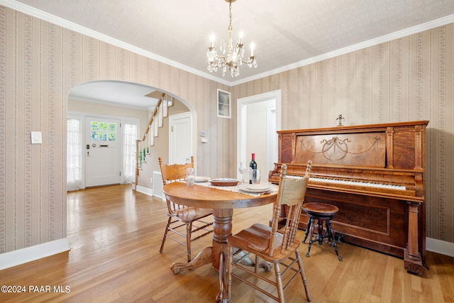 dining space with crown molding, light hardwood / wood-style flooring, and a chandelier