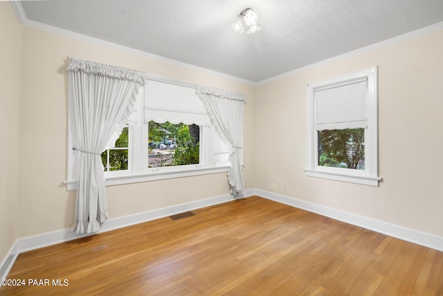 empty room with crown molding, a textured ceiling, and light hardwood / wood-style flooring