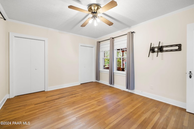 unfurnished bedroom with wood-type flooring, a textured ceiling, ceiling fan, and crown molding