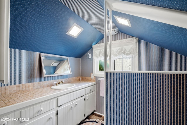 bathroom featuring vanity, hardwood / wood-style flooring, and vaulted ceiling