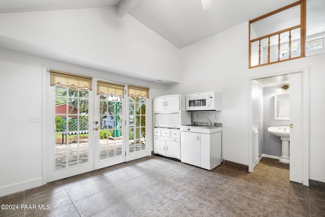 laundry area featuring cabinets, a high ceiling, tile patterned floors, and french doors