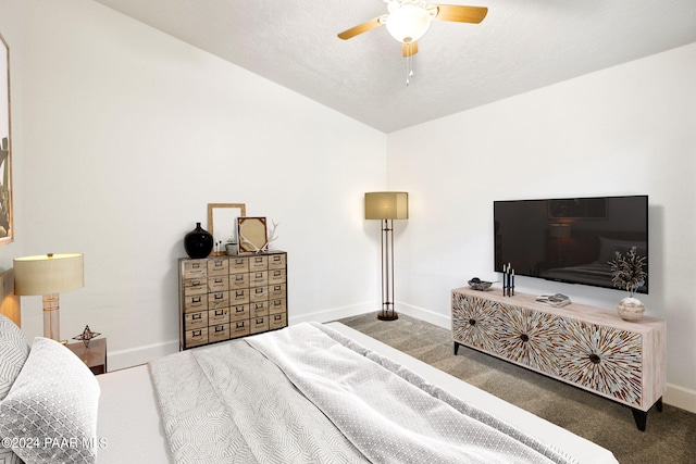 bedroom featuring dark colored carpet, ceiling fan, and a textured ceiling