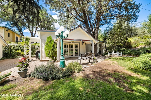 rear view of property featuring a pergola, french doors, and a deck