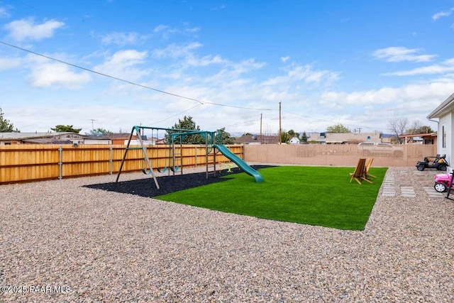 view of playground with a fenced backyard and a yard
