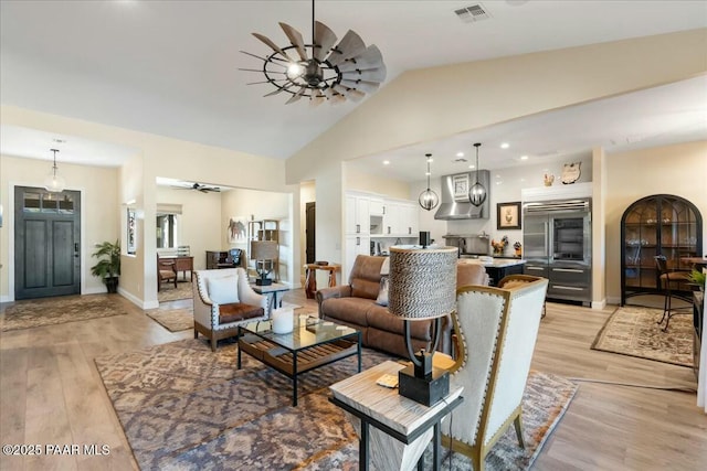 living room with lofted ceiling, light wood-type flooring, and ceiling fan