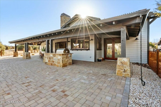 view of patio / terrace featuring a bar and an outdoor kitchen