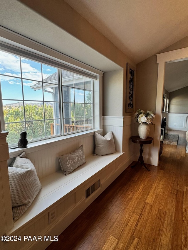 sitting room with wood-type flooring and vaulted ceiling