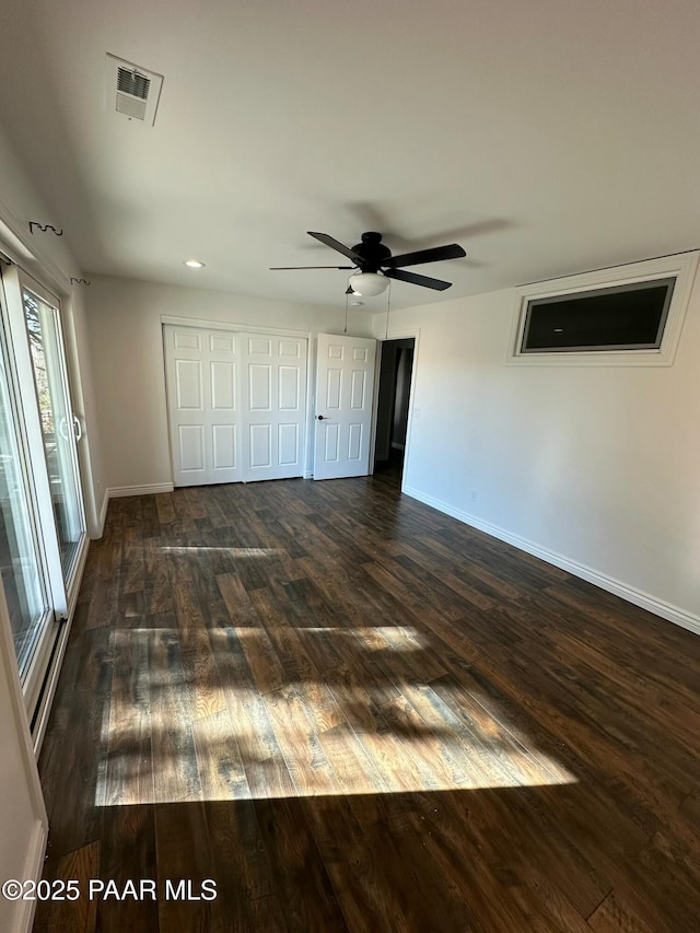 unfurnished bedroom featuring dark wood-type flooring and ceiling fan