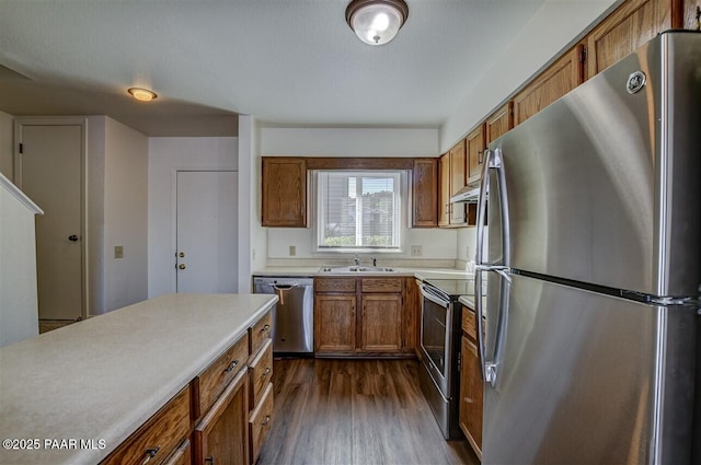 1242 Stetson Rd Unit 21, Prescott, AZ 86303 - kitchen featuring appliances with stainless steel finishes, brown cabinets, under cabinet range hood, dark wood-style floors, and light countertops