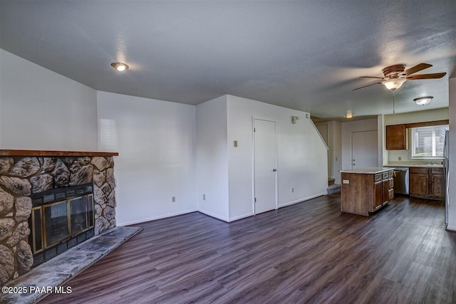 1242 Stetson Rd Unit 21, Prescott, AZ 86303 - unfurnished living room featuring dark wood-style floors, a ceiling fan, and a stone fireplace