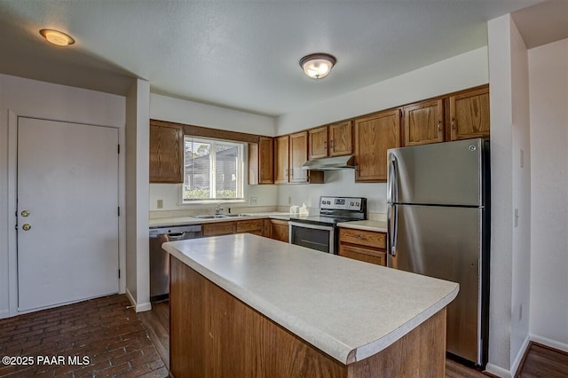 1242 Stetson Rd Unit 21, Prescott, AZ 86303 - kitchen with appliances with stainless steel finishes, under cabinet range hood, light countertops, brown cabinetry, and a kitchen island