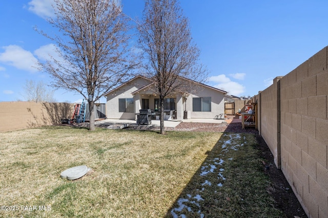 back of house featuring a patio, a yard, and a fenced backyard