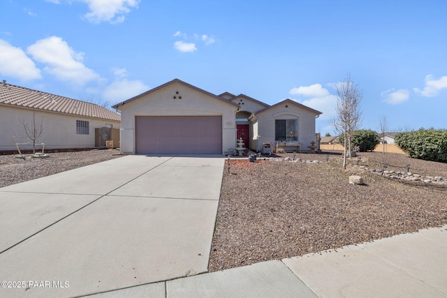 ranch-style house featuring stucco siding, an attached garage, and driveway